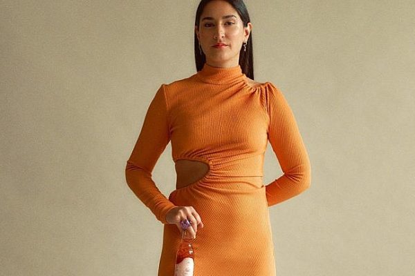 Entrepreneur Anika Sawni stands holding one of her signature alcohol-free sangrias.