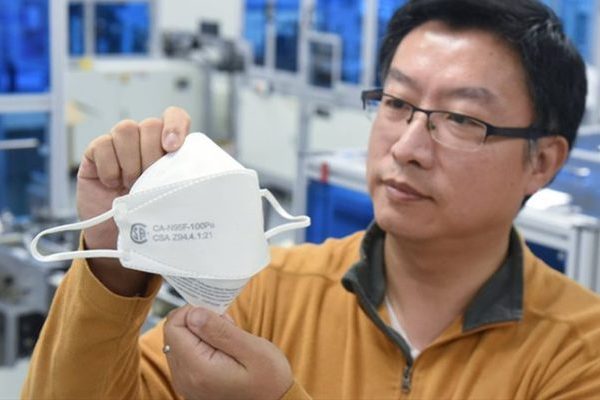 Anthony Zhao, president and CEO of CANADAMASQ, holding a medical-grade, flat-fold disposable respirator mask