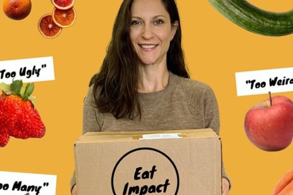 Woman holding a box displaying words "Eat Impact" - yellow background with floating fruits and vegetables