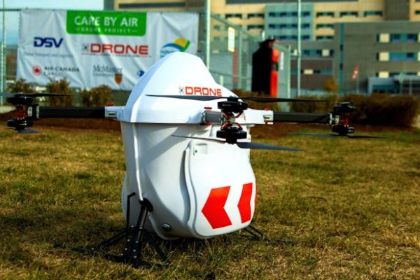 Drone Delivery Canada drone parked on grass in front of a building