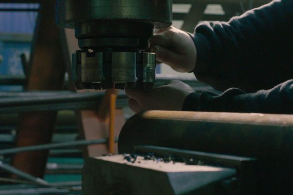 Close up of men's hands screwing the milling cutter on the milling machine