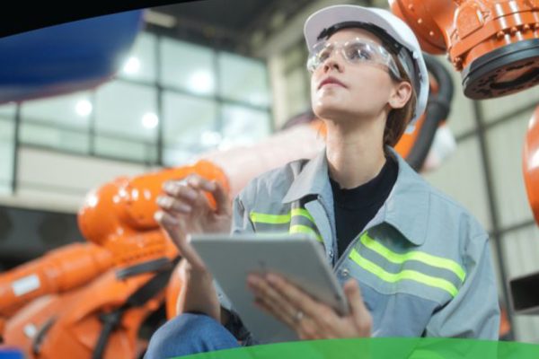 Person working in front of robots in manufacturing facility