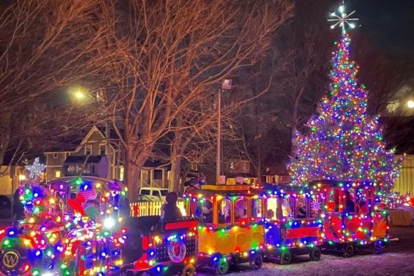 Christmas market at night with kids train lit up with Christmas lights in the Aurora town park