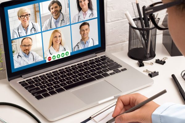 Female Doctor Having Meeting With Colleagues Via Video Call