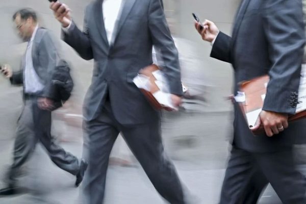 A man in a suit looking at a phone