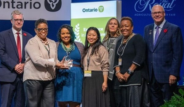 Award recipients holding award and smiling