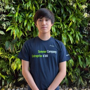 Photo of Liam in front of a green plant wall